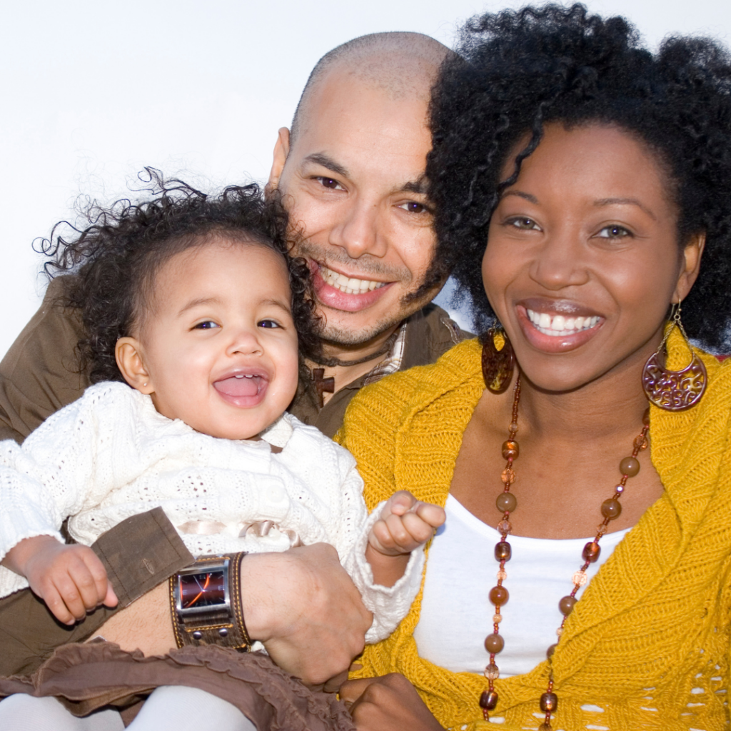 Imagen de la Semana de la Salud Mental de las Minorías de una mamá con camisa hola papá con un lognsleev verde oliva y bebé con el pelo rizado con un suéter blanco
